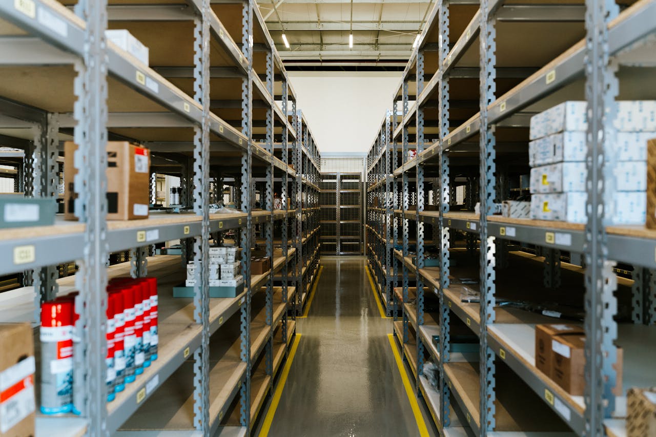 Wide view of an organized industrial warehouse with metal shelving and stored merchandise.